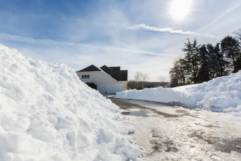 Piles of snow cleared from residential driveway