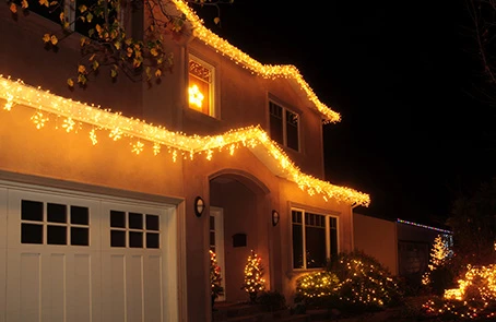 Two-story home lit with holiday lights.