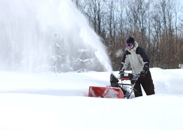 Man using a snowblower to clear snow