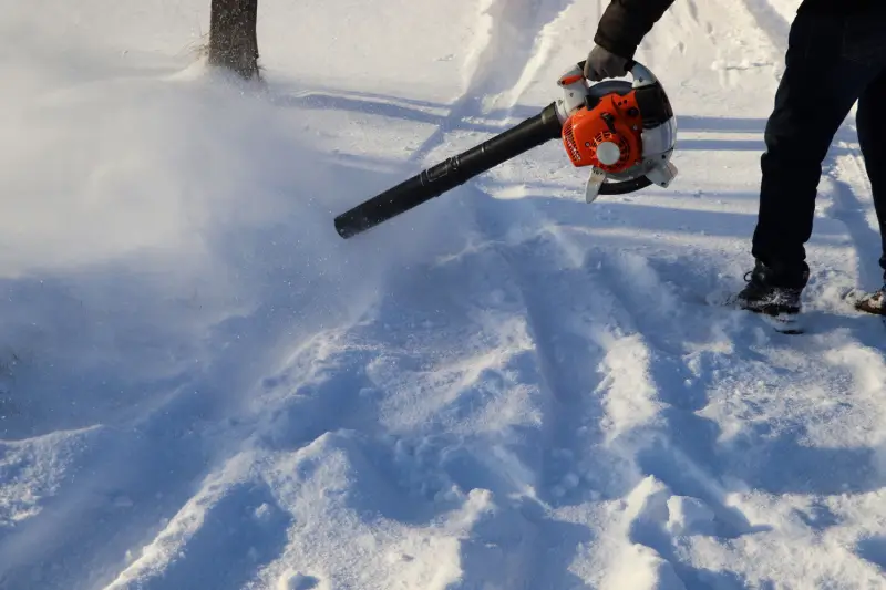 Person using a leaf blower for snow removal