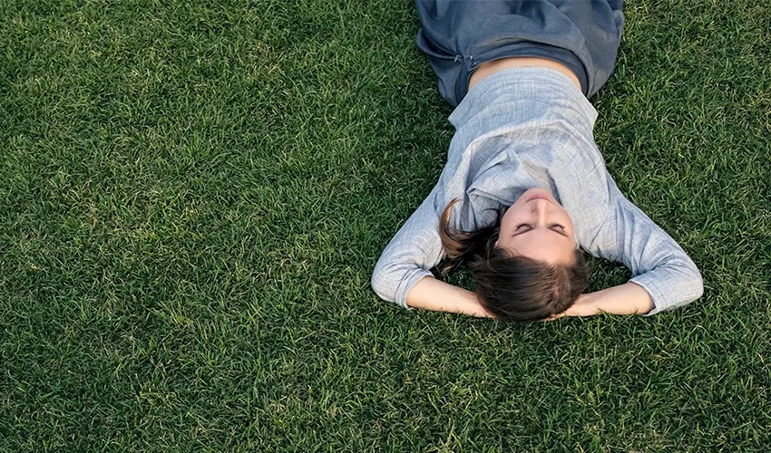 Woman laying on grass.