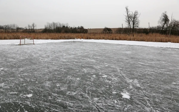 An ice hockey net sitting on an outdoor rink