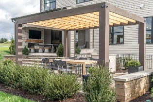 Outdoor patio area of a residential home with a pergola, table, and chairs.
