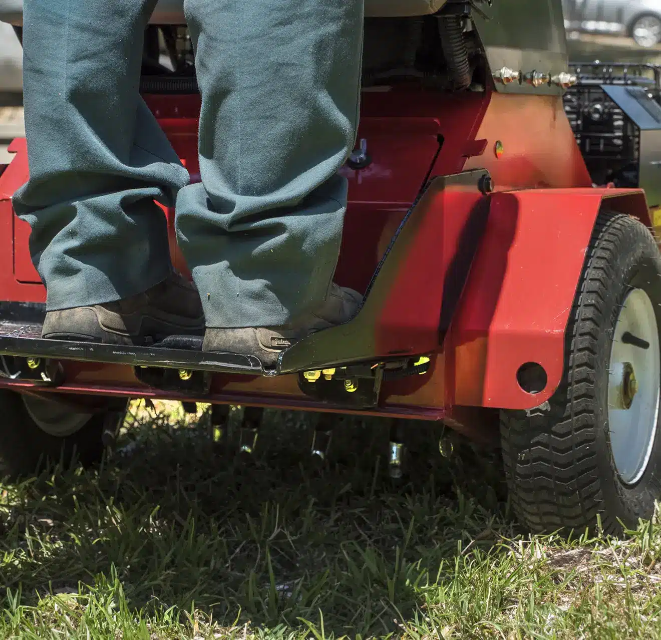 The back of a stand-on aerator in operation.
