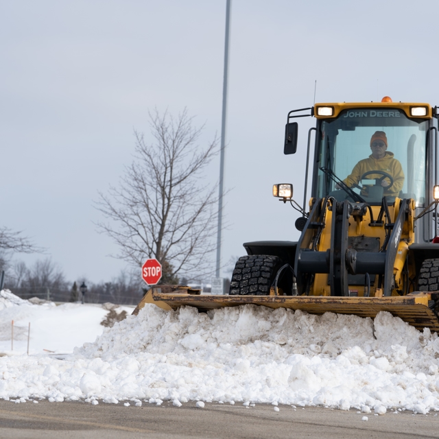 Ground guy employee removing snow using a vehicle